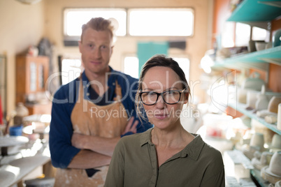 Male and female potter standing in pottery workshop