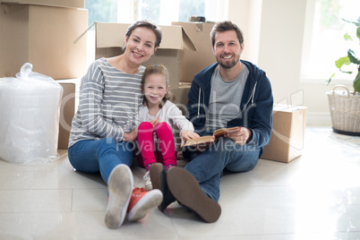 Parents and daughter reading books in living room