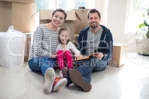 Parents and daughter reading books in living room