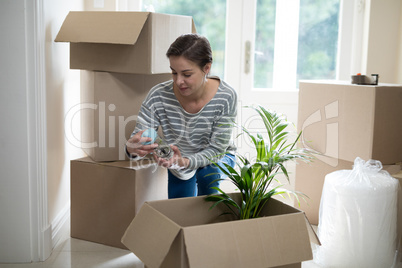 Woman opening cardboard boxes in living room