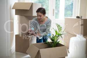 Woman opening cardboard boxes in living room
