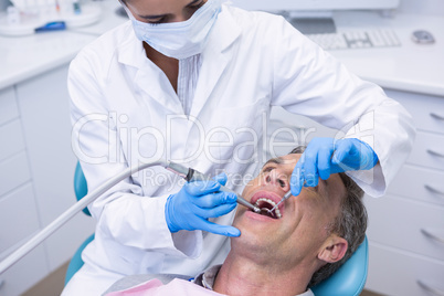 Dentist examining patient at clinic