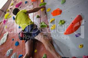 Low angle view of athlete rock climbing in fitness club