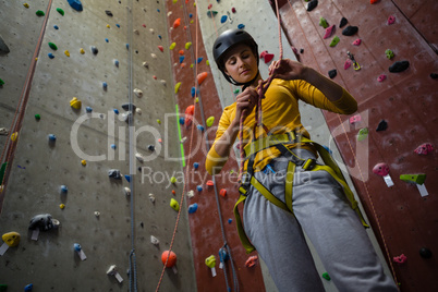 Low angle view of female athlete tying rope in health club