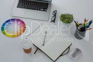 Laptop, spectacles, color swatch and stationery on white background