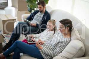 Parents and daughter using electronic devices