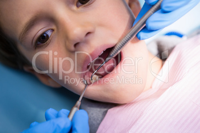 Dentist giving treatment to boy at medical clinic