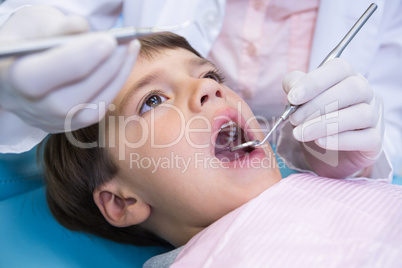 Close up of dentist holding equipment while examining boy