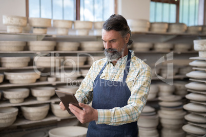 Male potter using digital tablet