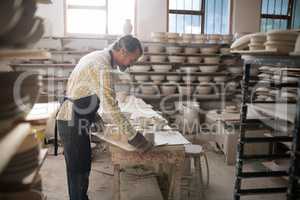 Male potter working at worktop