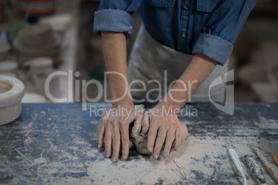 Mid section of female potter molding a clay