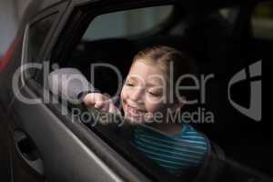 Teenage girl looking through car window