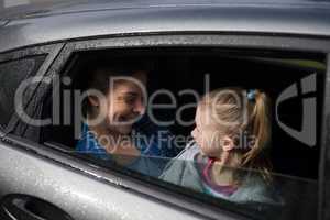 Mother and daughter interacting in the back of the car