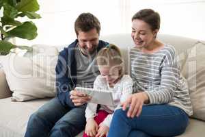 Parents and daughter using digital tablet