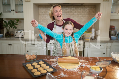 Mother and daughter having fun while preparing cookies in kitchen