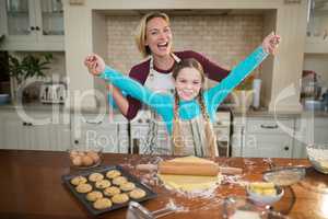 Mother and daughter having fun while preparing cookies in kitchen