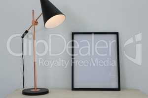 Picture frame and illuminated lamp on table