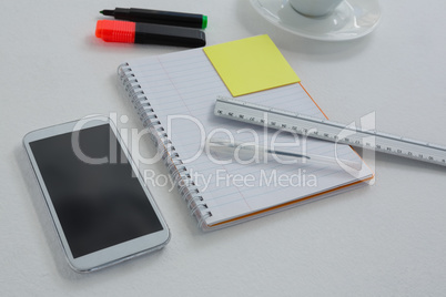 Mobile phone and stationery on white background