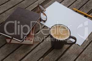 Organizer, coffee, spectacles, pencil and paper on wooden plank