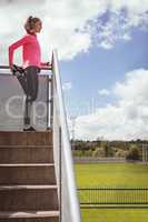 Woman performing stretching exercise in the stairs