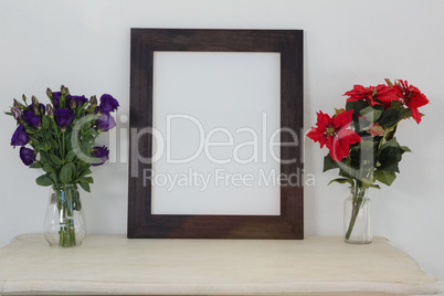 Picture frame and flower vase on table