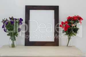 Picture frame and flower vase on table