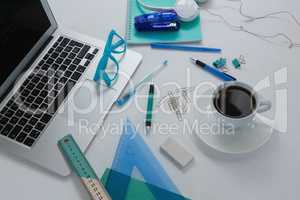 Laptop, black coffee and stationery on white background