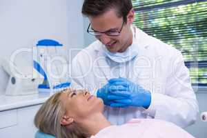 Smiling dentist looking at patient