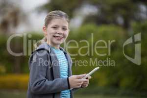 Young girl holding digital tablet in the park