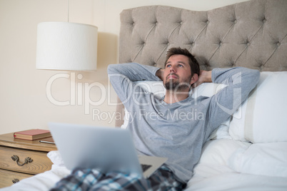 Man using laptop in bed