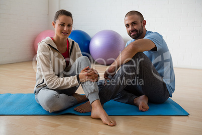 Portrait of student and yoga instructor relaxing in health club