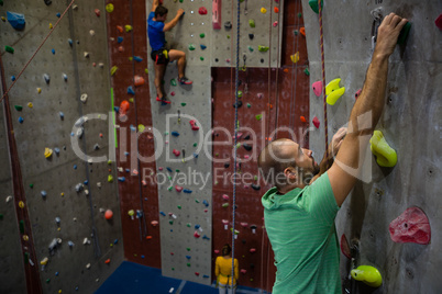 Confident athelets climbing wall in club