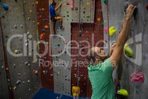 Confident athelets climbing wall in club