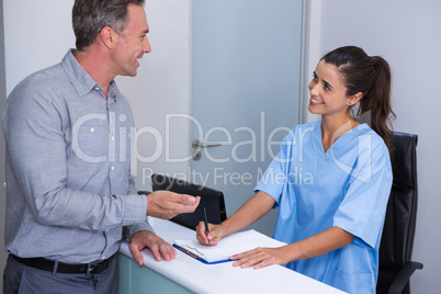 Smiling doctor and patient talking at desk