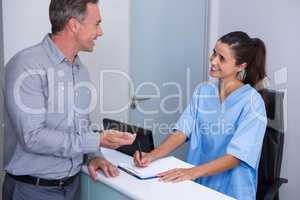 Smiling doctor and patient talking at desk