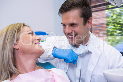 Cheerful patient looking at dentist while sitting on chair