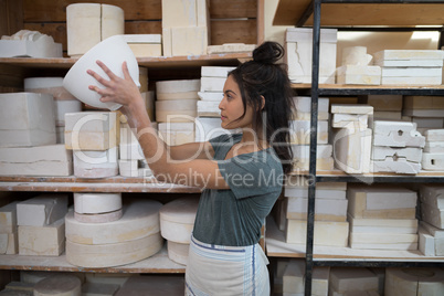 Female potter checking bowl