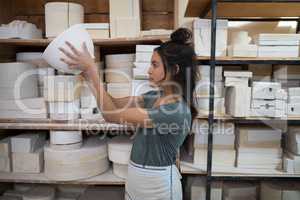 Female potter checking bowl