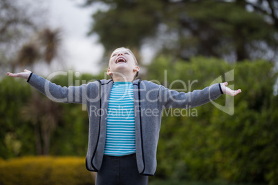 Girl standing in the park with arms wide open