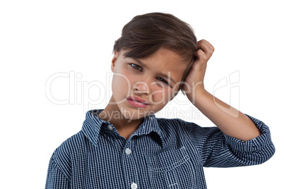 Depressed boy standing against white background