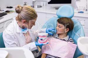 High angle view of dentist holding dental mold while examining boy