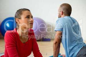 Student with instructor doing cobra pose in yoga studio