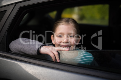 Smiling teenage girl looking through car window