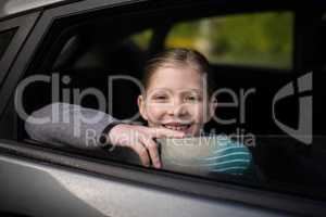 Smiling teenage girl looking through car window