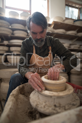 Male potter molding a clay