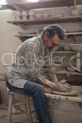 Male potter molding clay