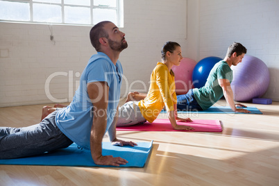 instructor with students practicing cobra pose in health club