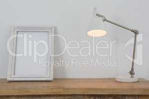 Picture frame and illuminated lamp on table