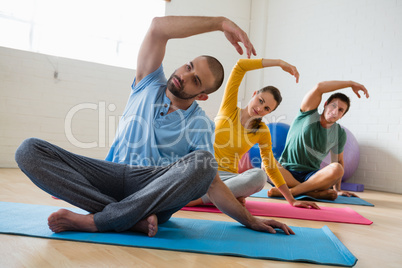 Instructor with students exercising at yoga studio