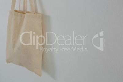 Beige bag hanging against white wall